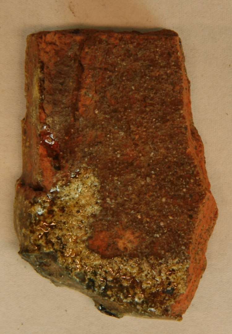 1 rødbrændt, glaseret 1 fragment, formentlig af glaseret tagsten.