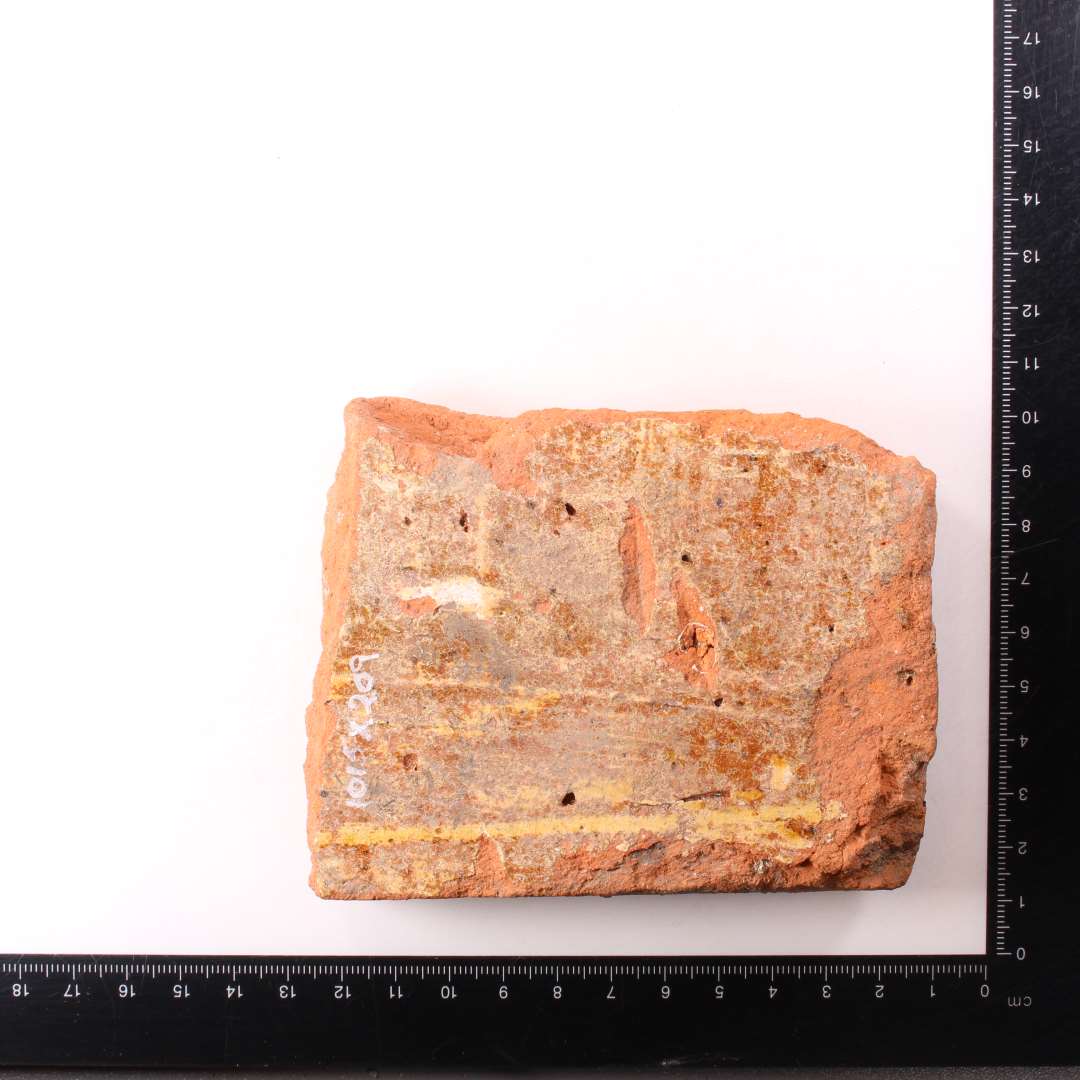 Fragment af kvadratisk gulvflise. Pibelersdekoration under glasurlag. Tykkelse: 2,5 cm.