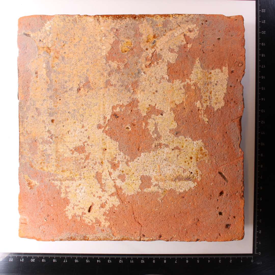 Kvadratisk gulvflise. Pibelersdekoration under glasurlag. 18,5x18,5 cm.Tykkelse: 2,5 cm.
