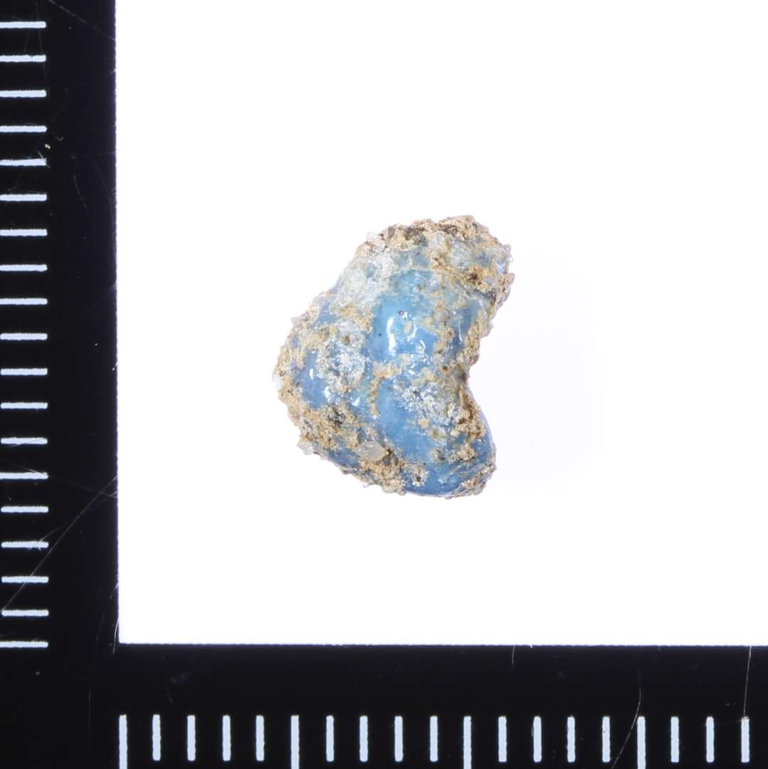 Fragment, Halv-gennemsigtig Blå
Delvist smeltet. Fastgroet materiale på overfladen.