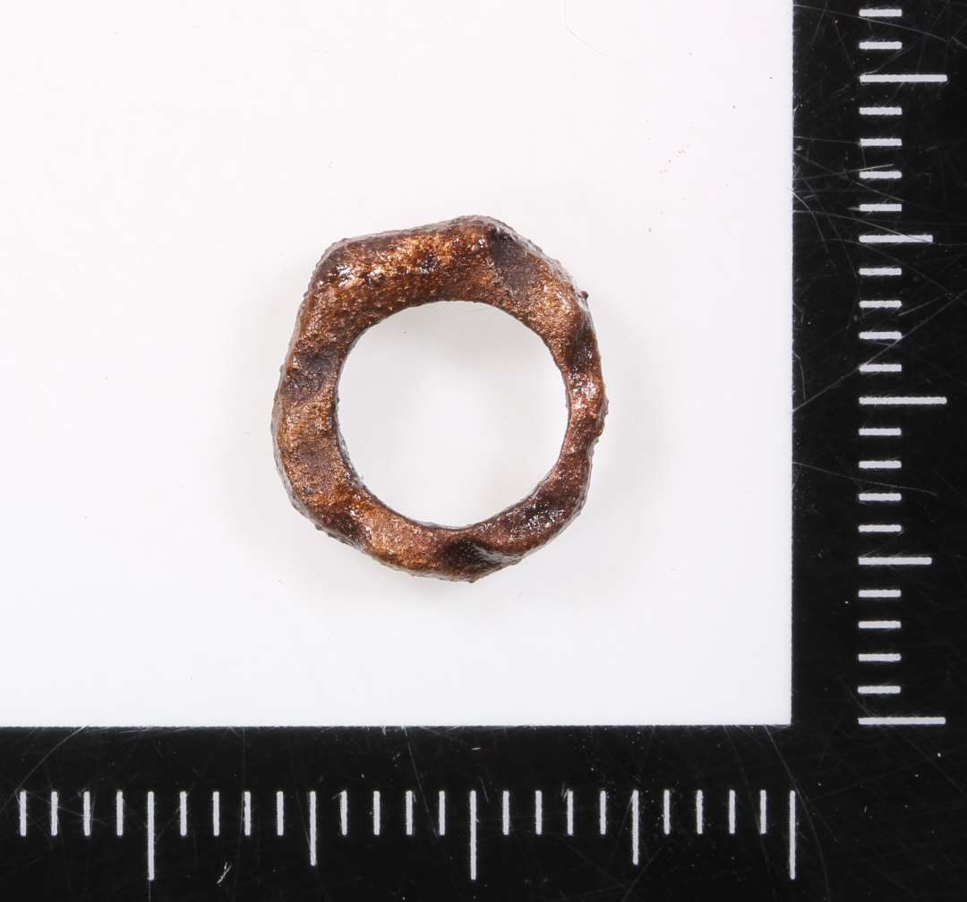 Bronzering. Uregelmæssig, lille. Ydre diameter ca. 1,1 cm.