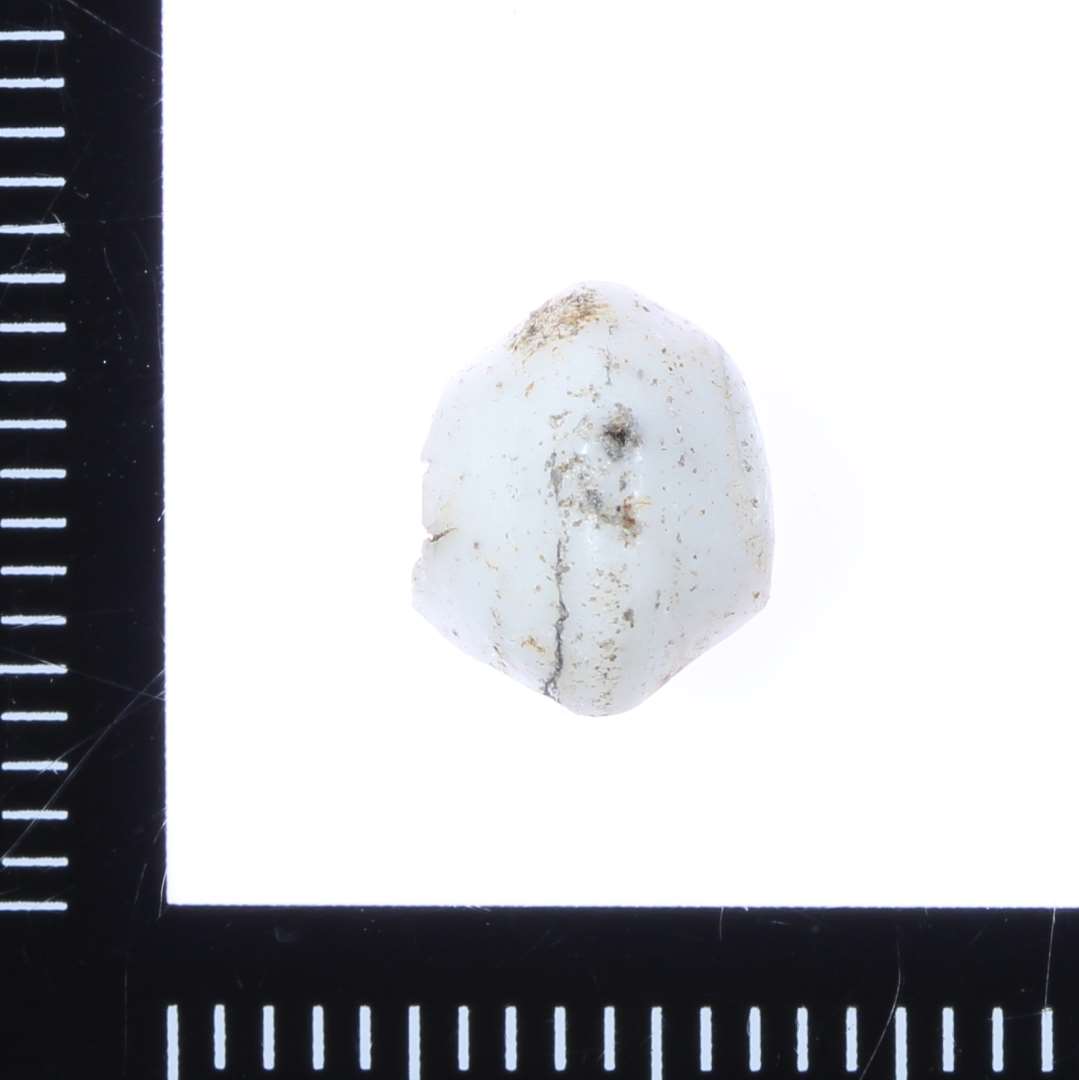 Fragment af dobbeltkonisk perle i mælkehvidt glas. 0,7 cm i tykkelse.
