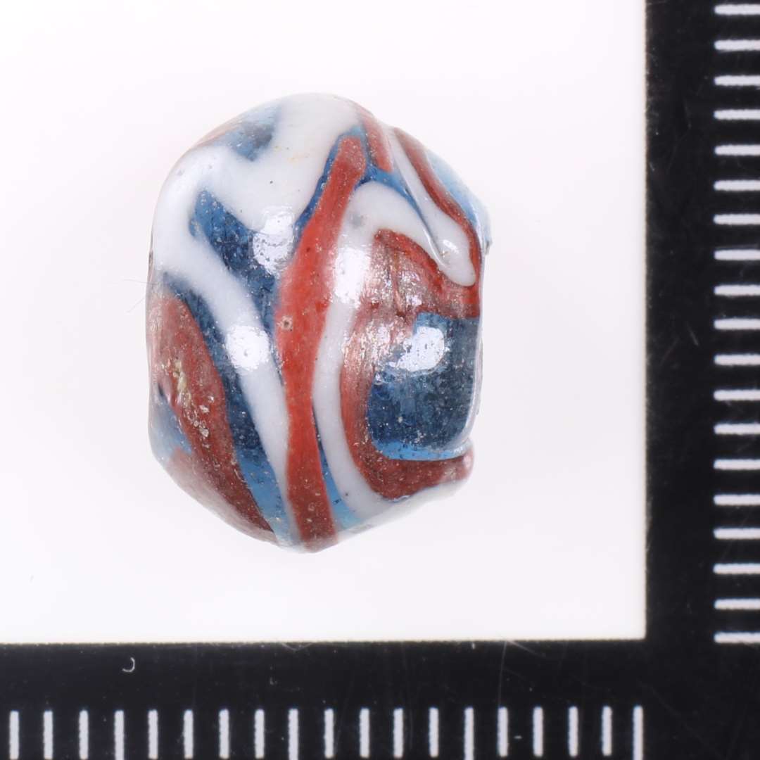 Dobbeltkonisk halv gennemsigtig blå Ribeperle med rødt og hvidt uregelmæssigt slyng