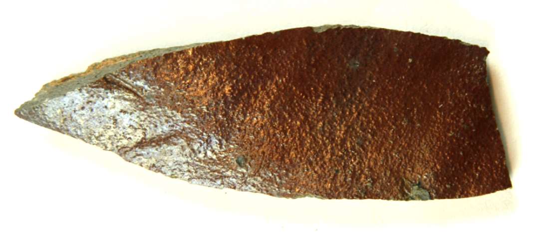Bugskår af gråligt fingrynet, hårdtbrændt næsten stentøjsgods med manganbrunlig bemaling på ydersiden, der er dækket af klar saltglasur.