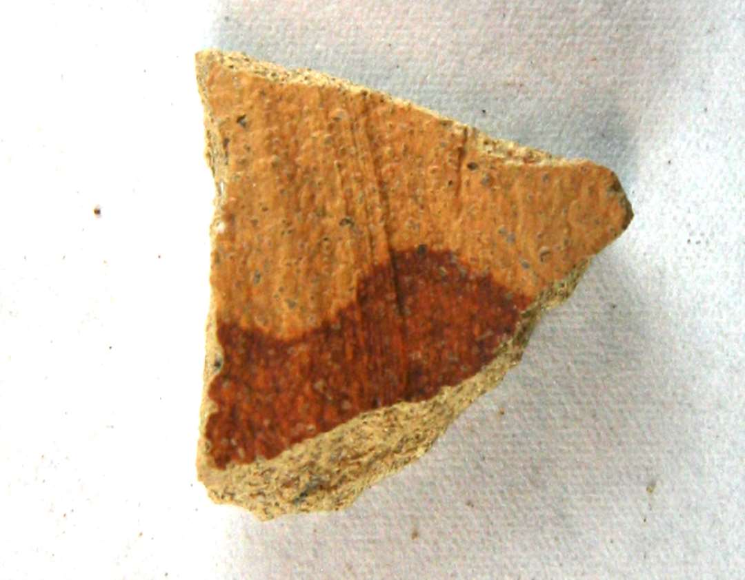 1 halsskår af gulliggråt, fingrynet, porøst lergods med spor af rødbrunlig dekorationsbemaling på ydersiden. (Pingsdorffvare).