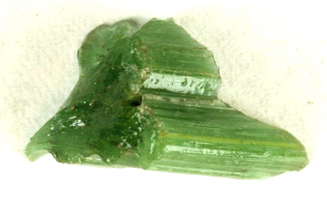 1 fragment af tykt stangformet glasstykke med uregelmæssig rillet yderside af grønligt delvis gennemsigtigt glas. Største mål: 1,5 cm.