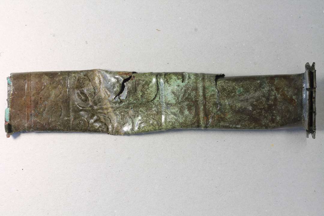  fragmenter af ornamenteret rør/skede/beslag. Konserveret.  Fladmast messingrør medomløbende blomsterornamentik, 1800-tallet.