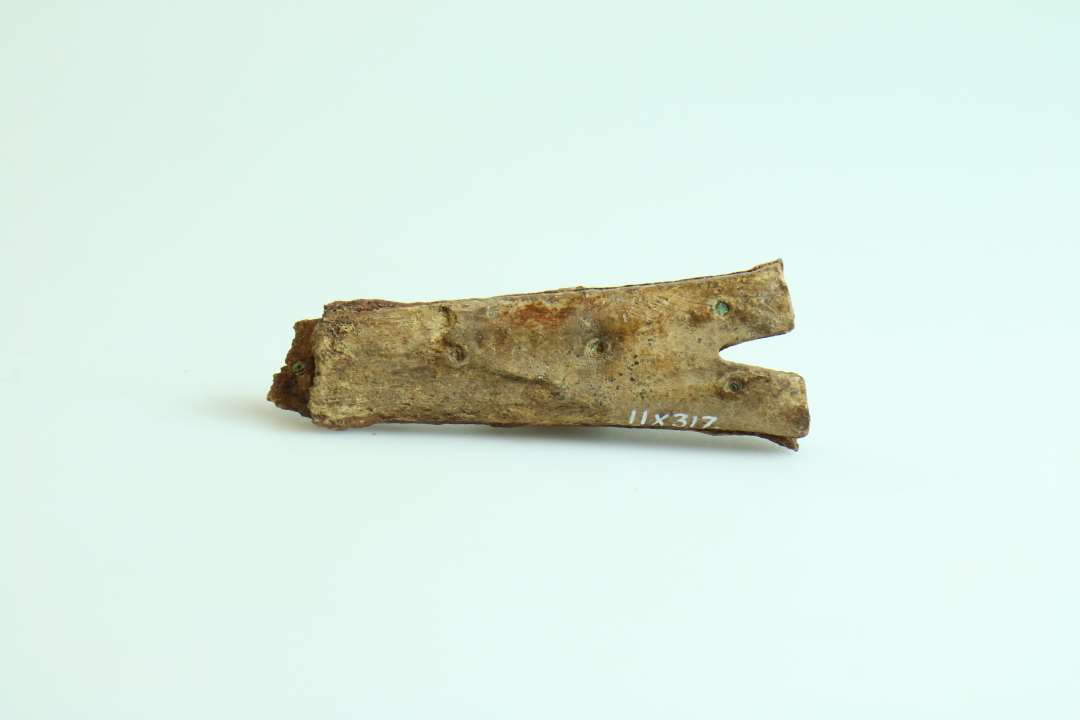7-8 cm langt skæfte fra kniv med 'kløft' i enden modsat bladet. Består af to stykker ben, som er nittet sammen om et stykke metal.