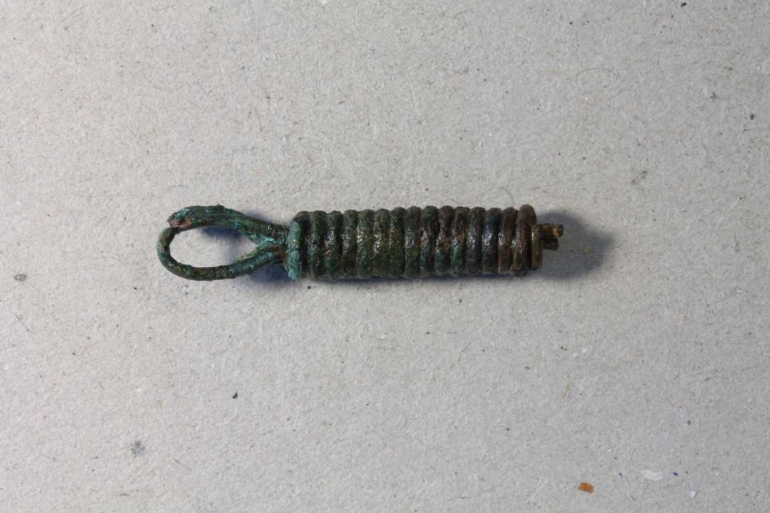 Kædeled fremstillet af omviklet bronze/kobbertråd. Sands. samhørende med x679. kons. Mål: 3,3 cm.