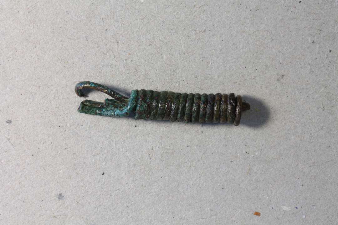 Kædeled fremstillet af omviklet bronze/kobbertråd. Sands. samhørende med x679. kons. Mål: 3,3 cm.
