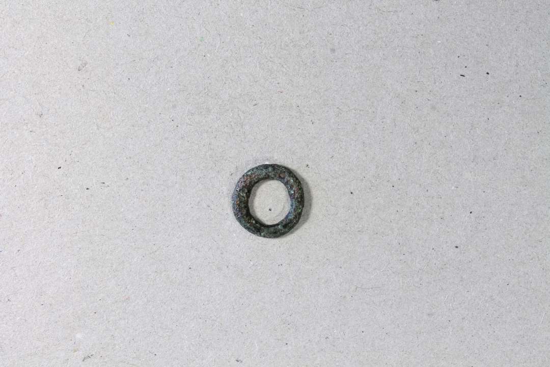 Lille ring. ø 8 mm. Måske pyntering i ringbrynje eller snørering fra dragt?