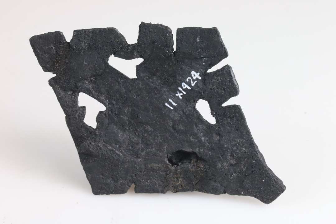 Rhombeformet jernbeslag med isiddende nitte og gennembrydninger. Sidelængde: 7 cm., Konserveret