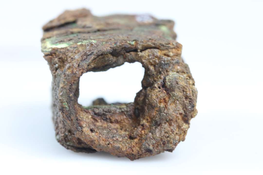 Fragment af låsehus. Jern og bronzeindhold. Største mål: ca 6,5 cm., Konserveret