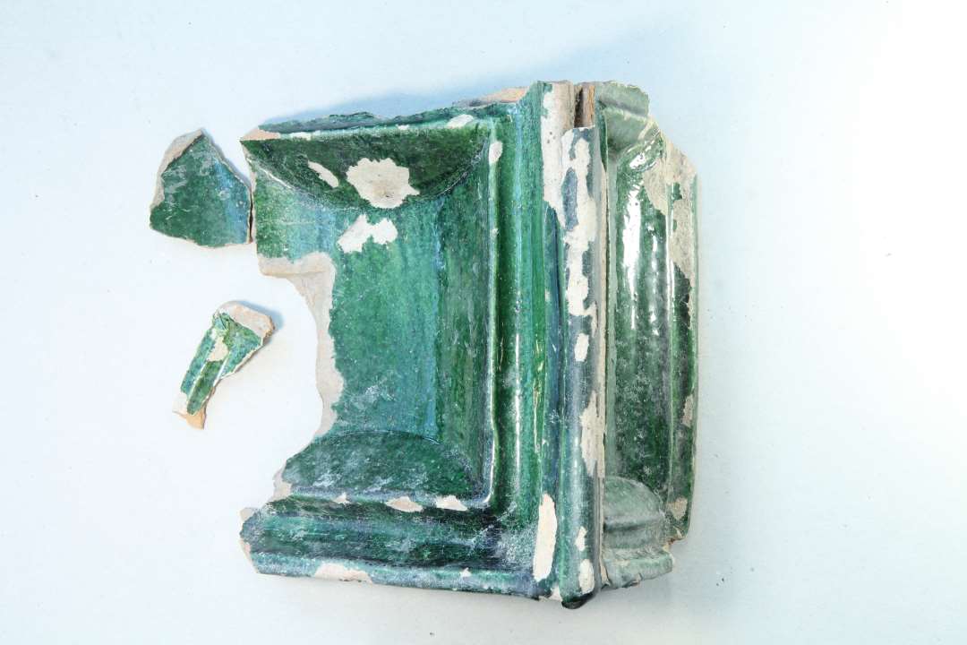 Grønglaseret hjørnekakkel.. Et stort fragment, Mål: 17x14,3 cm. samt to mindre skår. Uden motiv