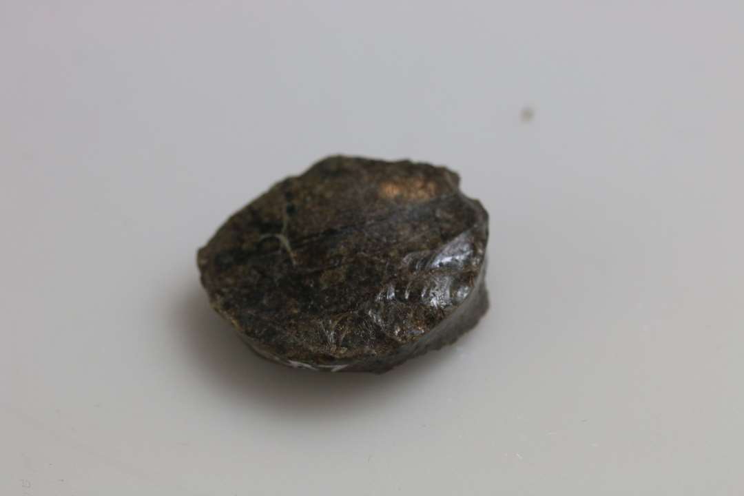 Bundskår fra meget lille beholder, et glas eller en 'salvekrukke', stammer fra midten af 1200-tallet. Ret nedbrudt. Diameter: ca 2,5 cm.