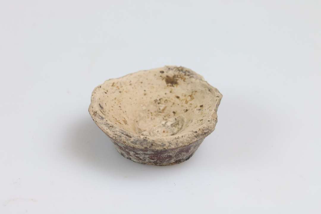 Bund af miniature lerkar/salvekrukke/rangle med flad bund og brun glasur. Bunddiameter: 1,8 cm.
