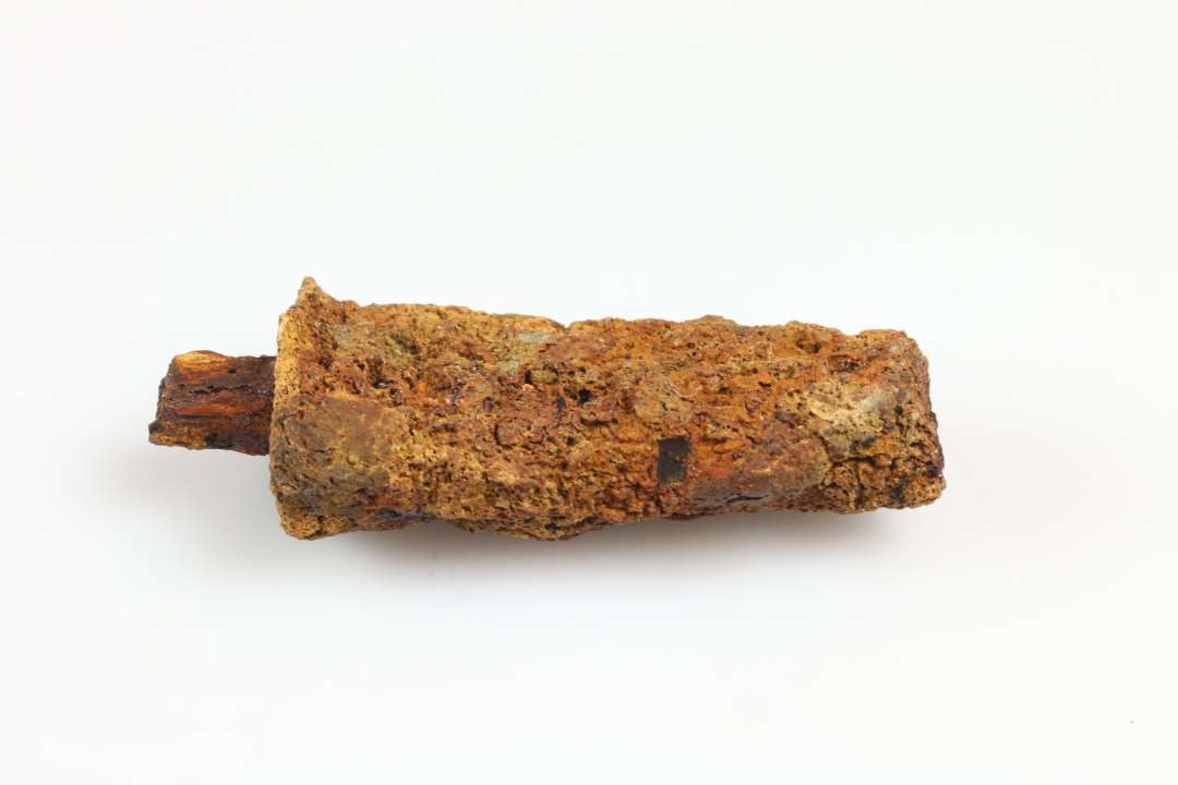 Knivskaft eller skaft til anden genstand med rest af organisk materiale (træ?). Længde: ca 6,5 cm., Konserveret
