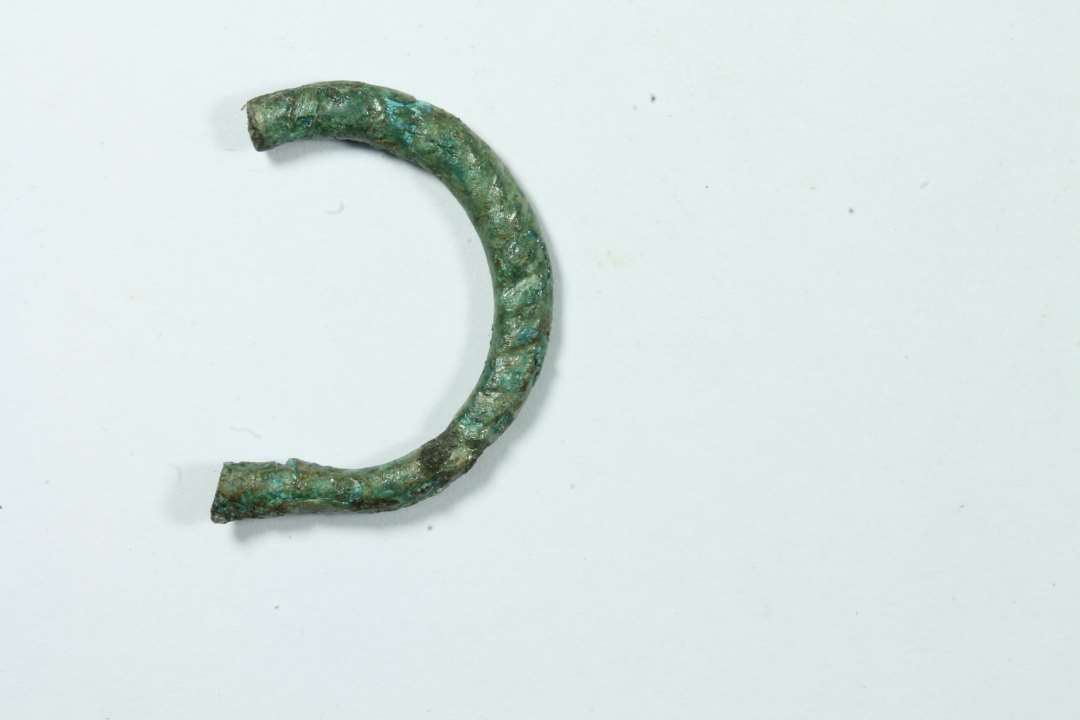 Fragment af vistnok D-formet spinkelt spænde med tovsnoet ornamentik. Største mål: 2,2 x 1,8 cm.