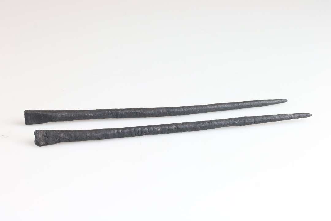 To aflange genstande af jern. Længde: 16,5 og 17 cm., Den ene ende flad, firkantet, den anden spids. Styli?/stylos? Konserveret