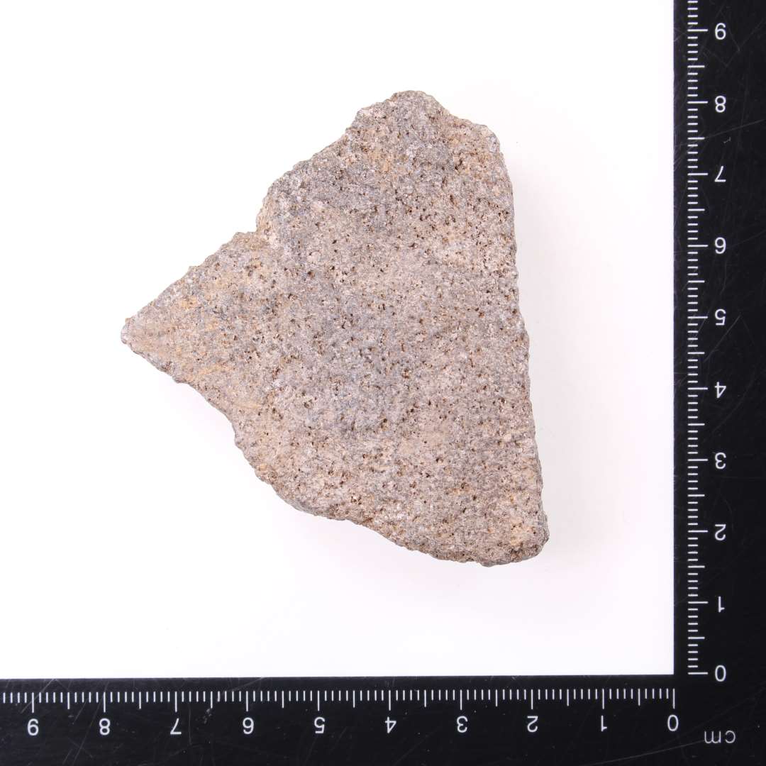 Fragment af klæberstensgryde, vægtykkelse 1,7 cm, hvor der i den ene brudflade ses resterne af et klinkehul, mål ca. 1,7 x 6,5 x 5,5 cm. 