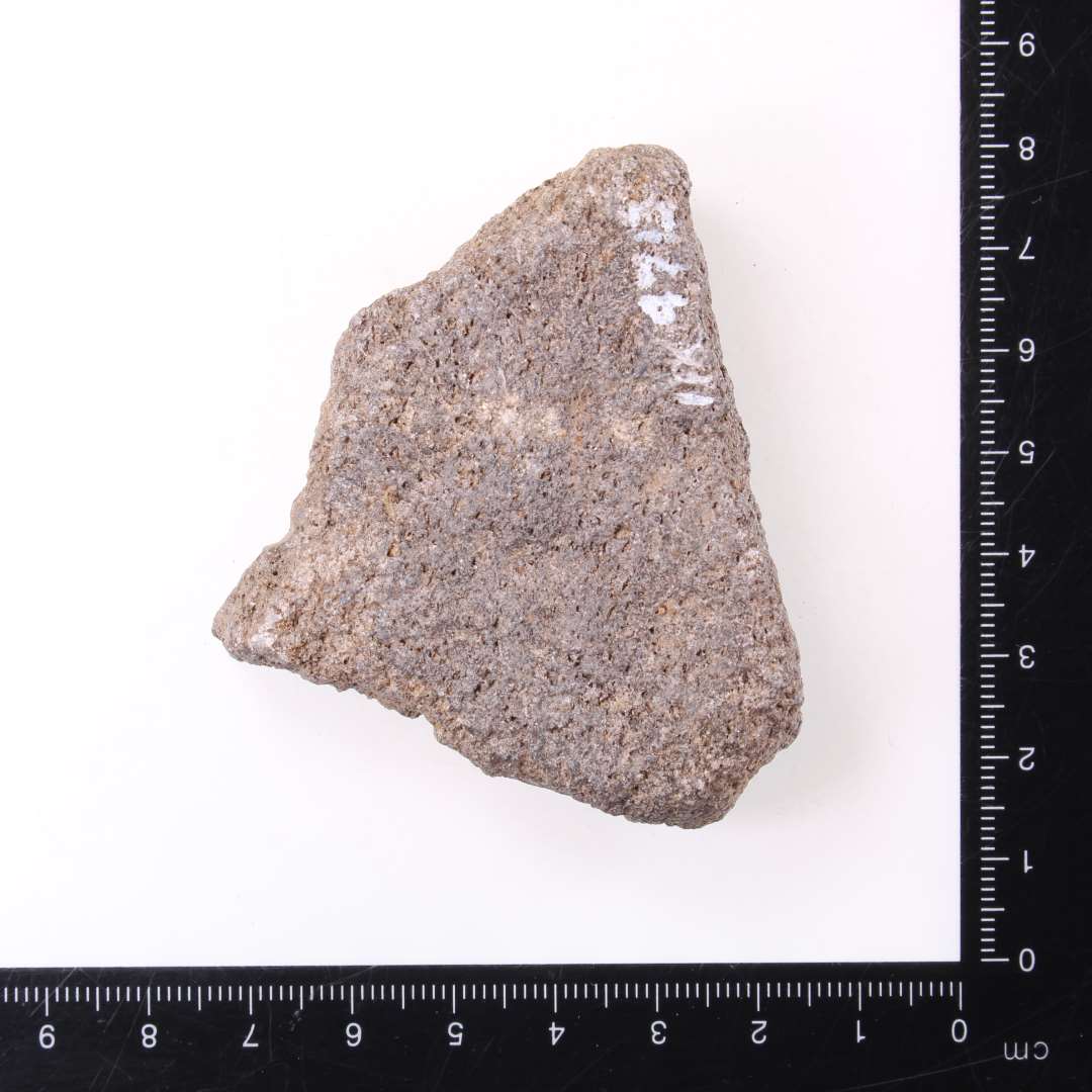 Fragment af klæberstensgryde, vægtykkelse 1,7 cm, hvor der i den ene brudflade ses resterne af et klinkehul, mål ca. 1,7 x 6,5 x 5,5 cm. 