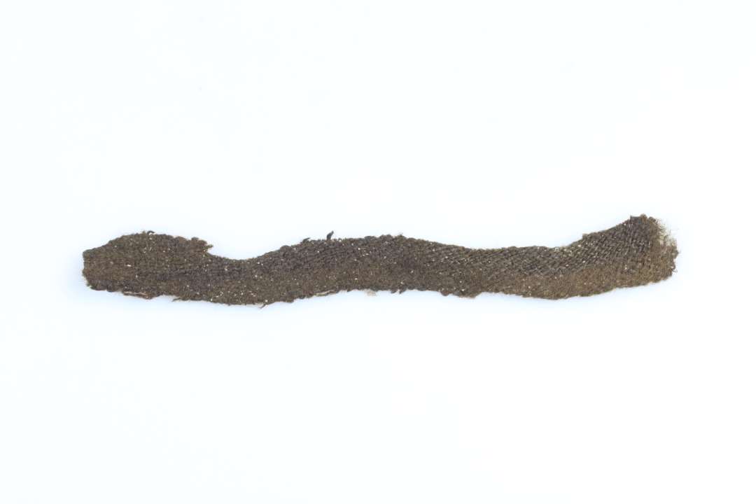Et stykke båndformet tekstil. Længde ca. 2x15 cm. islæt: 8 tråde s-spundet, trend:8 tråde z-spundet.