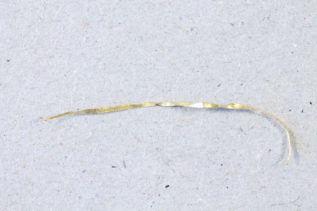 Guldtråd; ca. 3 cm. lang.