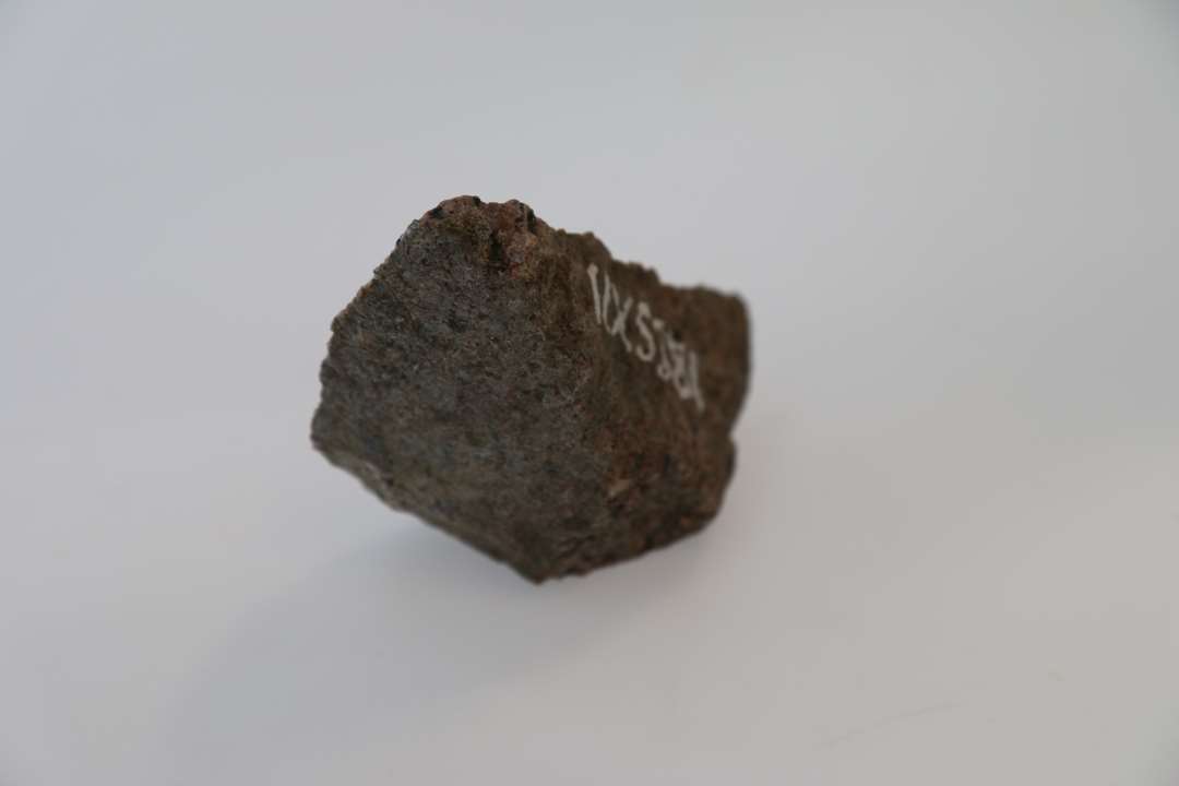 Vindueskvader af granit (afbrækket hjørne), hører sammen med x5382. Mål: 15,5xca 8 cm.