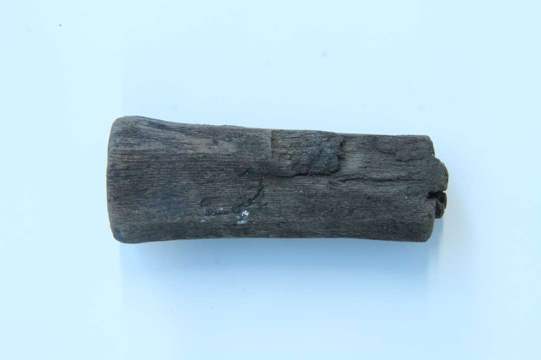 Bearbejdet træ (håndtag?)  Længde: 9 cm.