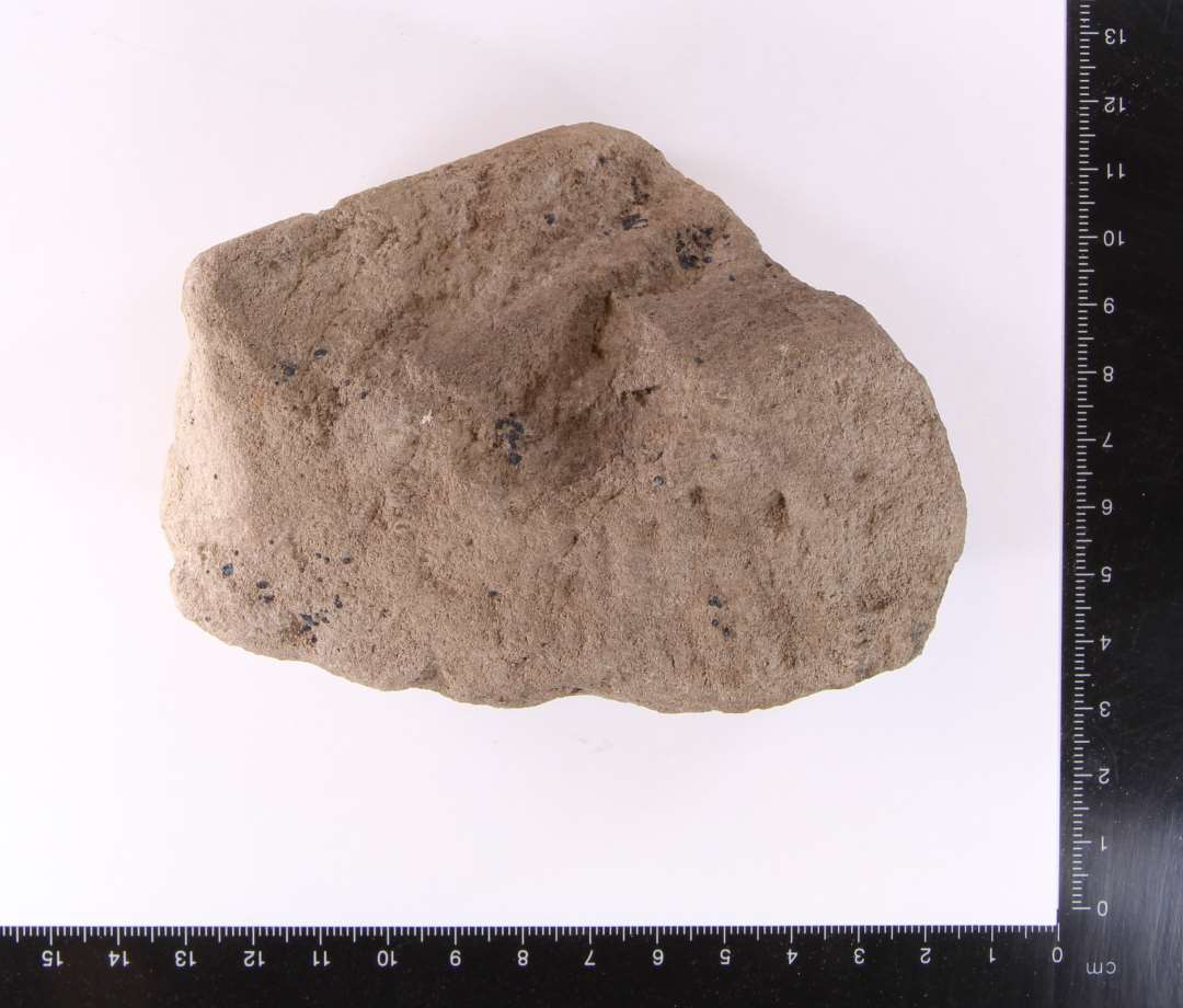 Muligt fragment af morter.  Bugskår fra morter, ret nedbrudt overflade. Største mål: 11,5 cm.
