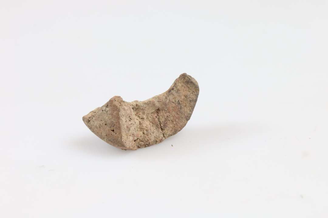 Lille fragment af konisk, facetteret tenvægt. Største mål: 3,2 cm.
