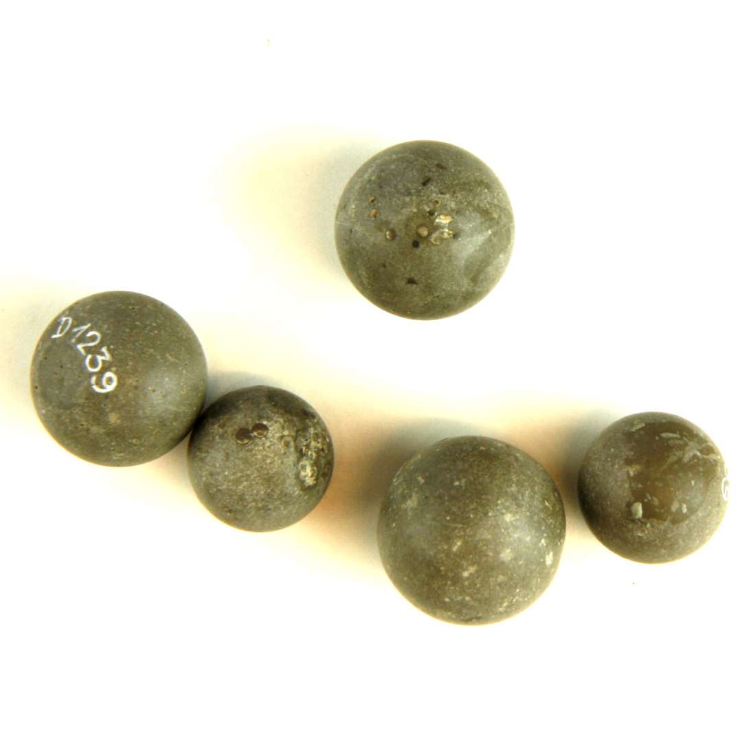 5 glatte stenkugler af grålig stenart. 2 af kuglerne er ufuldkomment tildannet idet de mangler en ubetydelig kuglekalot for at opfylde den fuldkomne kugleform. Kuglernes diameter er henholdsvis: 1,35 cm., 1,4 cm., 1,6 cm., og 1,75 cm.