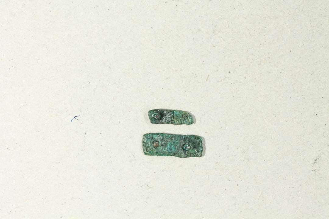 To små stumper bronze med nitter, ca 1,5 cm.