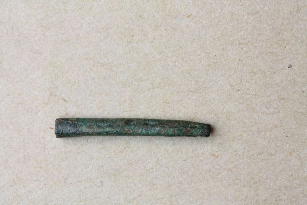 Fragment af kræmmerhusformet snøreendedup. Længde: 2,2 cm.