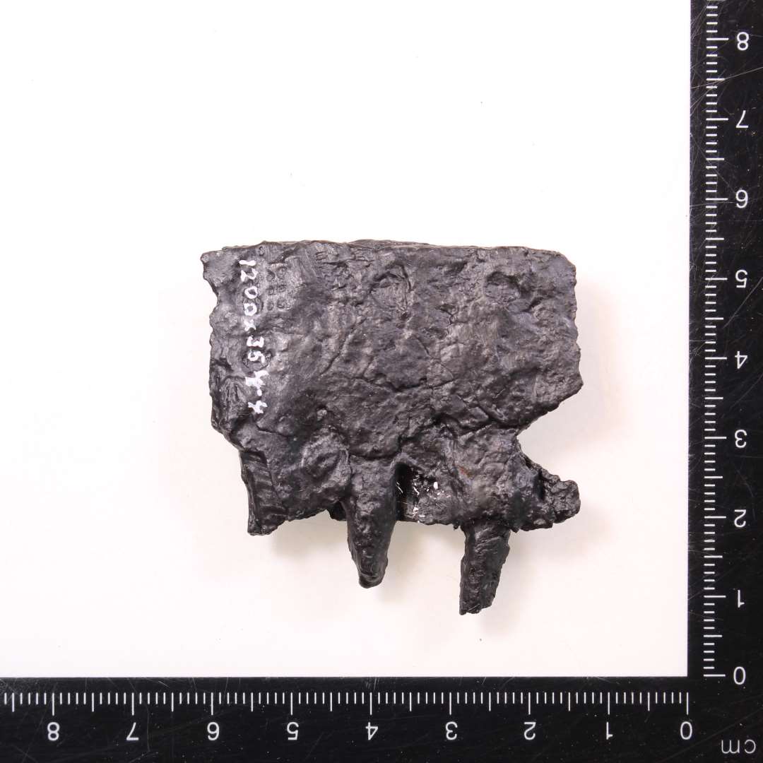 Fragment af beslag? To lag jern med tre tværliggende stykker jern. Mål: 5x5 cm. 