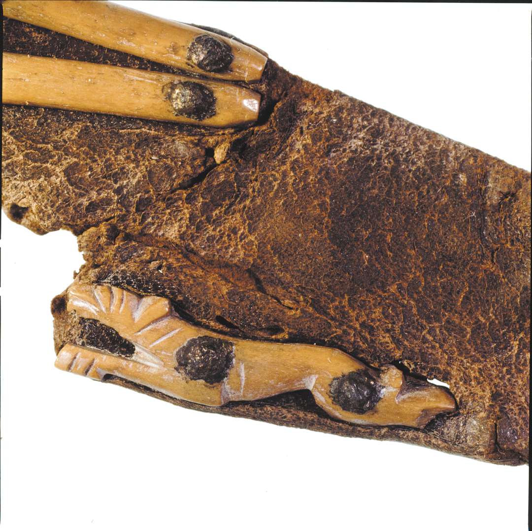 Knivskede af læder med pånittede benfigurer forestillende bl.a. hunde/løver? Længde: 21 cm., bredde: 3,5-5 cm.