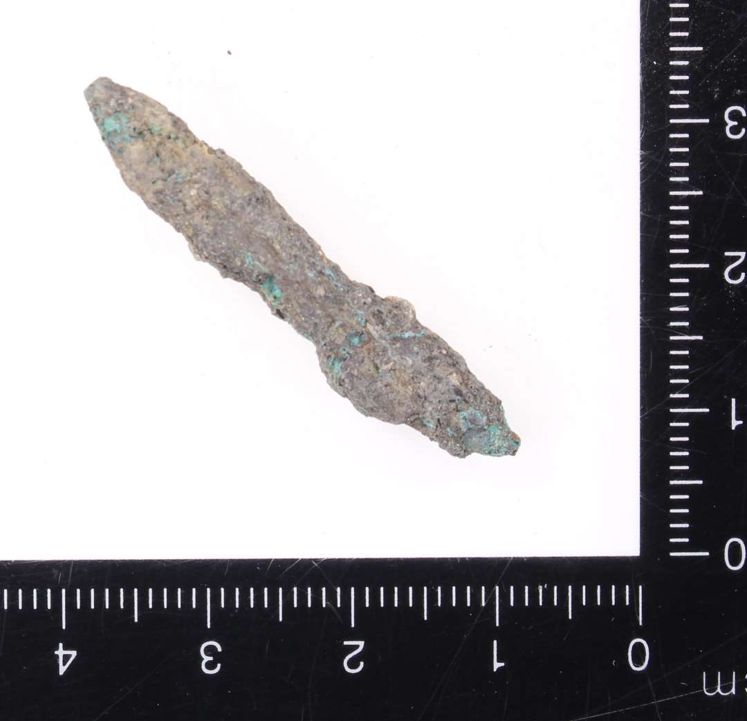 Stangformet fragment af kobberlegering. Længde: ca 4 cm.