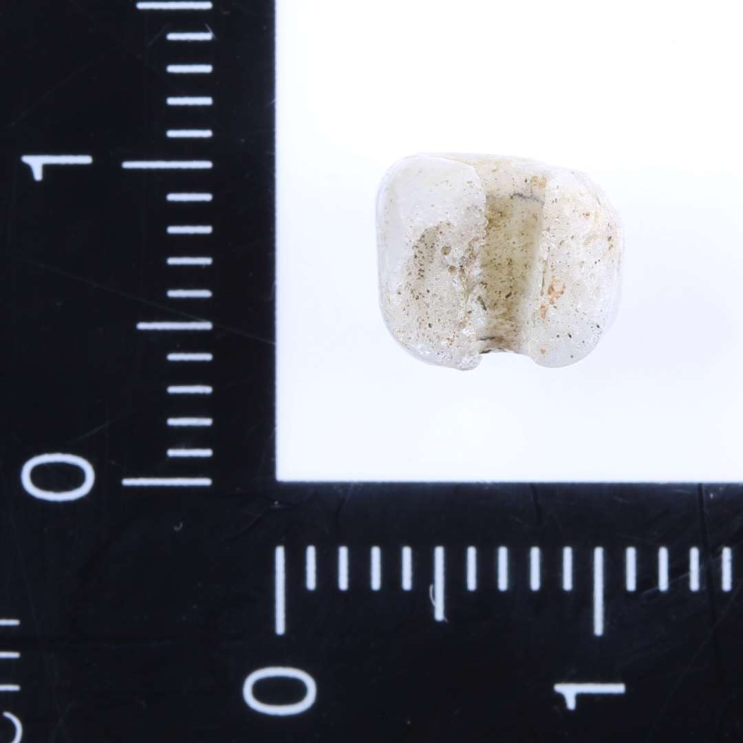 Fragment af velbevaret, cylindrisk perle af hvidt uigennemsigtigt glas. H 7 mm, ø 8 mm.