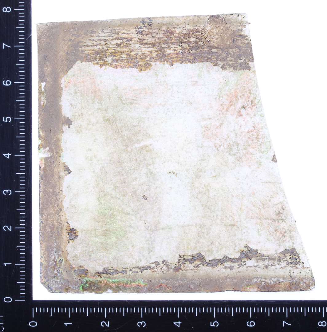 Større fragment af lille blyindfattet vinduesrude. Muligvis halvdel bevaret. Måler 7,6 x 7,5 cm. 