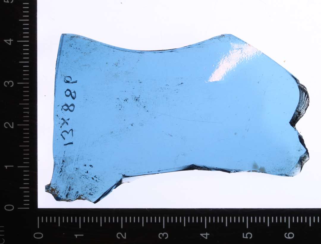 Større fragment af klart blåt glas.