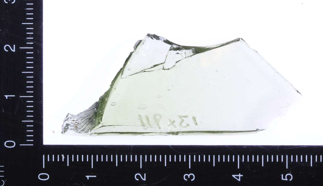 Ét fragment af buet ca. 0,2 cm tykt lyst grønt klart glas.