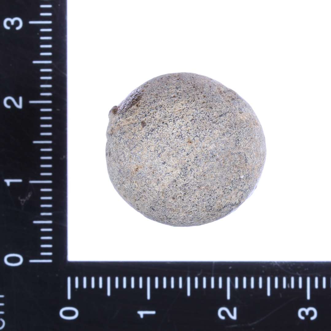Lille rund kugle af sten. Diameter 1,8 cm.