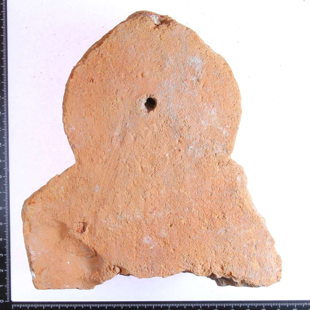 Fragment af ribbesten med styrehul. (Muligvis fingeraftryk ?.).  Største mål: 13x13x8 cm.  