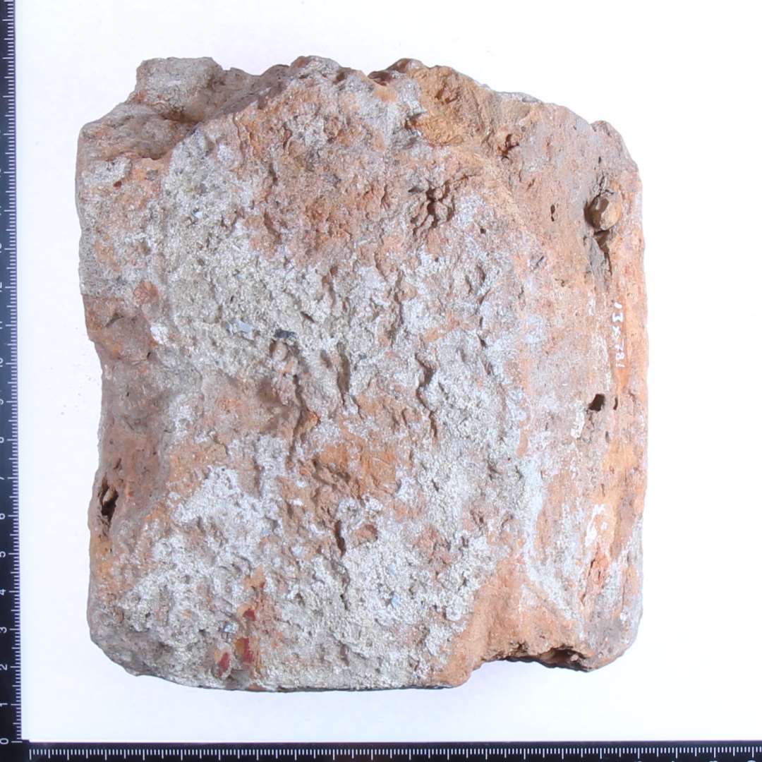 Fragment af formsten med mørtel. Største mål ca: 14x14x5cm.