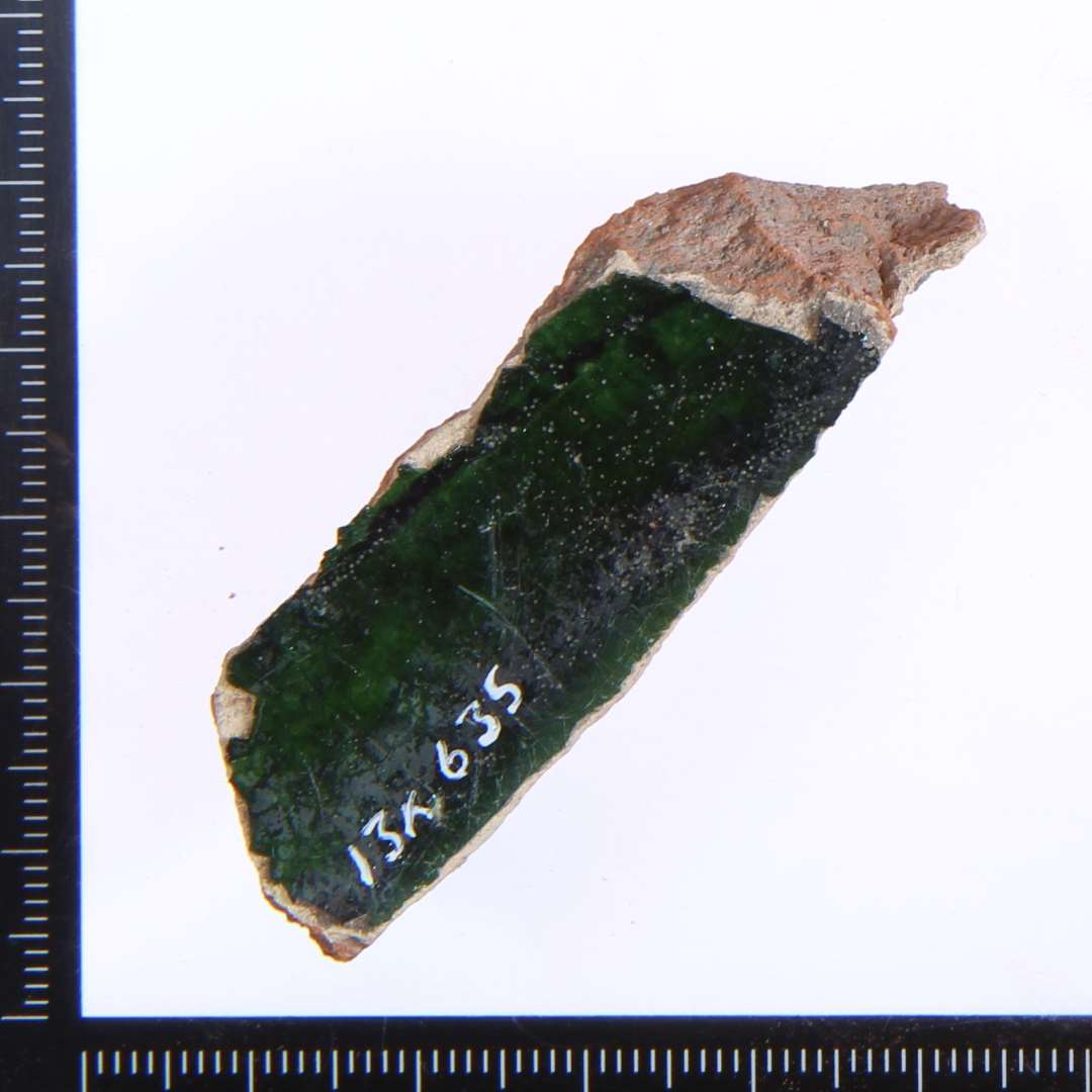 Et lille fragment med grøn glasur. Største mål:ca 5x2 cm.