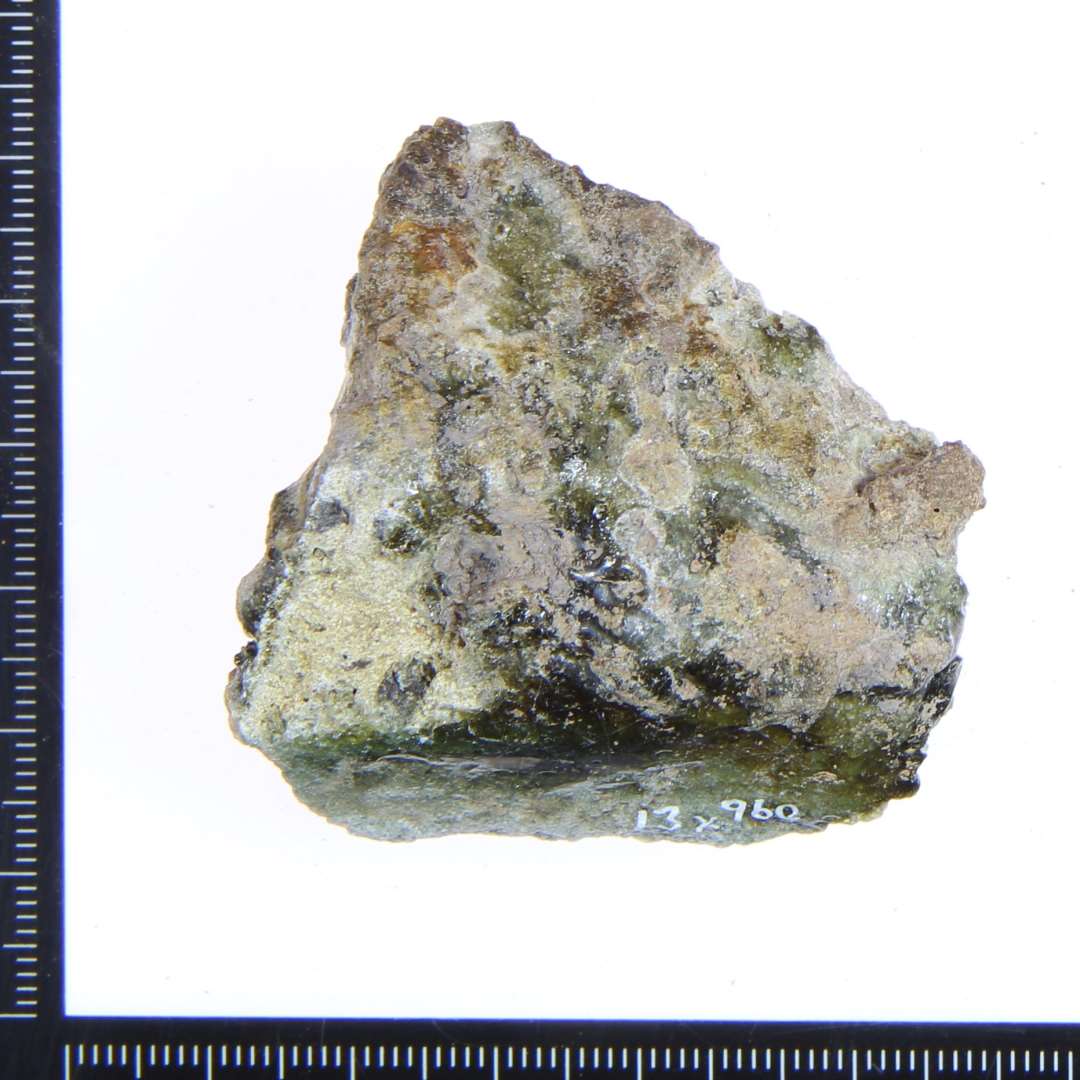 Et lille gråbrændt fragment af gulvflise? med grøn/lysegrøn glasur.
