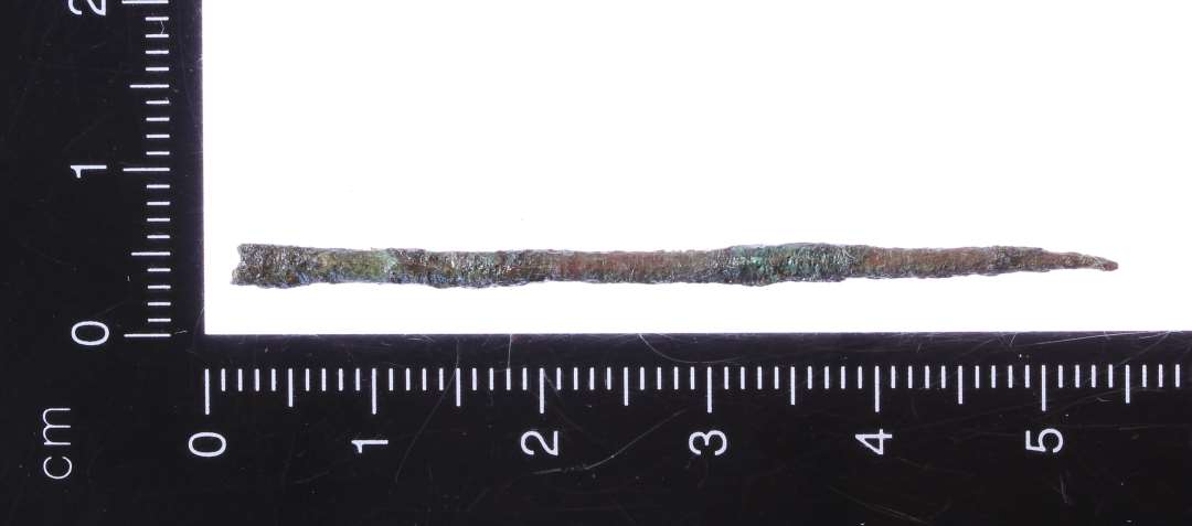 Del af nål af kobberlegering. 5,5 cm lang. Hoved/øje mangler.