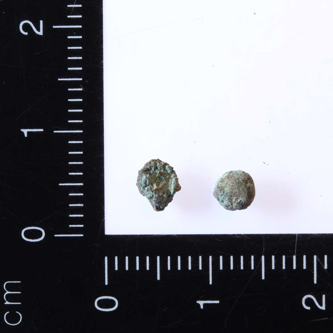 To små kugler af kobberlegering/Bronze. Ca. diameter 0,3 cm.
