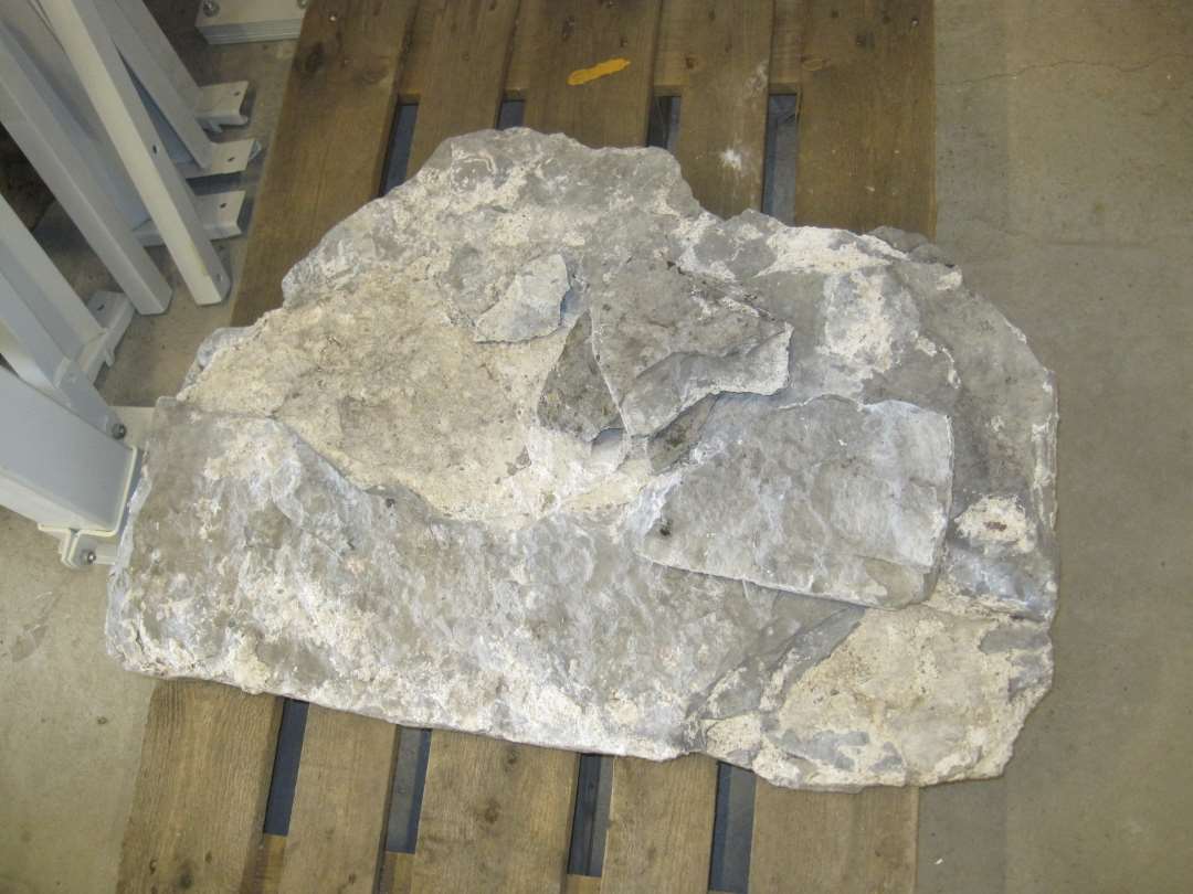 Fragment af gravsten af namurkalksten, Mål: 92x66x11,5 cm., samt nogle mindre affalgede stykker.
