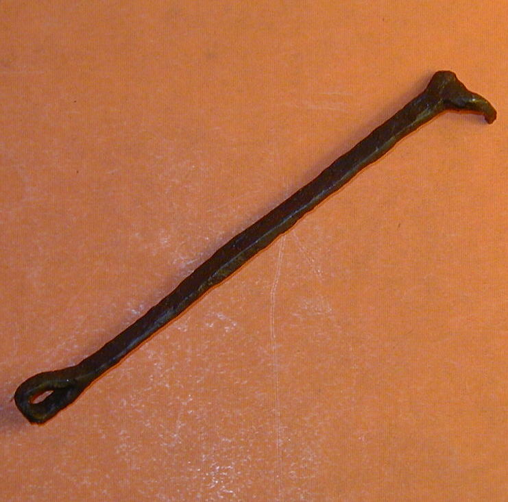 Nøgle til hængelås i form af en 'mini'-kødkrog dvs. to let buede krogformede tappe ved den ene ende. Den anden ende afsluttet i nydelig ombøjet øje. Samlet længde 10 cm.